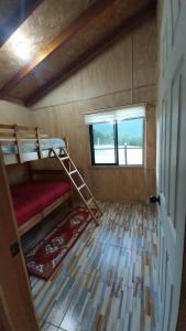 a small room with bunk beds and a window at Cabañas la Estrella in Neltume