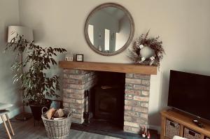 a mirror sitting on top of a brick fireplace at Tumbledown Croft, rural cottage near Cruden Bay in Peterhead