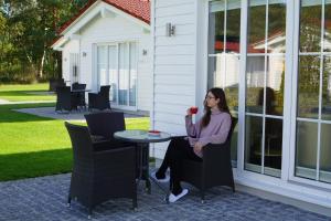 a woman sitting at a table with a rose at Havellandhalle Resort - Hotel, Sport und Wellness in Seeburg