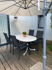einen Tisch und Stühle unter einem Schirm auf einer Terrasse in der Unterkunft Ferienwohnung Eisele in Buchenberg