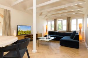 una sala de estar con un sofá y una mesa en Baltisches Haus, App 05, en Heringsdorf