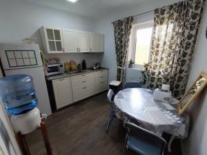 una cucina con tavolo e sedie e una cucina con finestra di Double bedroom in St Julians in shared house a San Giuliano