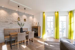 uma sala de jantar com uma mesa e cortinas amarelas em Beachhouse Bansin App 14 em Bansin