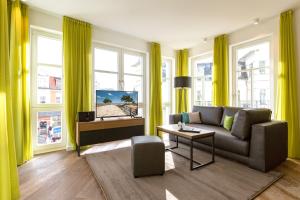 uma sala de estar com cortinas amarelas e um sofá em Beachhouse Bansin App 14 em Bansin