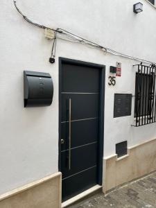 una puerta negra en el lateral de un edificio en Sunny Holiday Terrace Apartment, en Almuñécar