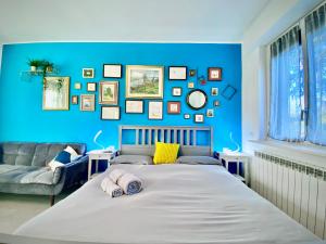 a blue bedroom with a bed and a couch at Casa Francesca Malpensa Milano in Busto Arsizio