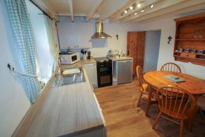 a kitchen with a wooden table and a table and chairs at Greenside Cottage Caldbeck in Caldbeck