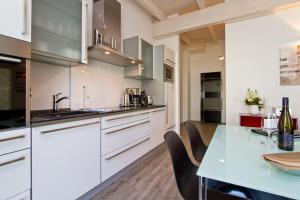 a kitchen with white cabinets and a table with chairs at Domizil am Hang App A04 in Heringsdorf