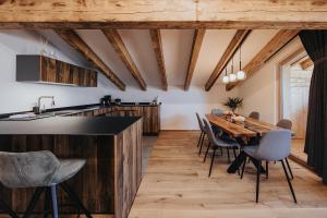 eine Küche und ein Esszimmer mit einem Holztisch und Stühlen in der Unterkunft Alpin Chalet Samer Apt Fürstenblick in Sarntal