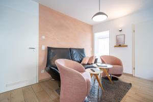 - un salon avec un canapé et des fauteuils en cuir dans l'établissement Domizil Duene 8 App 3, à Ahlbeck