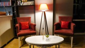 uma sala de estar com duas cadeiras, uma mesa e um candeeiro em BERRY BELLA HOTEL em Marmaris