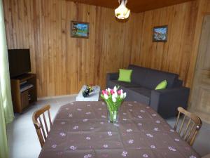 a living room with a table with flowers on it at Lou R'bat Pays in Le Grand-Bornand