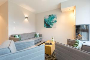 ein Wohnzimmer mit Sofas und einem TV in der Unterkunft Domizil Düne 8, App. 6 in Ahlbeck