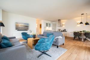 ein Wohnzimmer mit einer Couch und Stühlen und einem Tisch in der Unterkunft Domizil Meerzeit, App. 7 in Ahlbeck