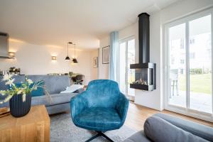ein Wohnzimmer mit einem blauen Stuhl und einem Sofa in der Unterkunft Domizil Meerzeit, App. 7 in Ahlbeck