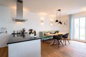 eine Küche und ein Wohnzimmer mit Tisch und Stühlen in der Unterkunft Domizil Meerzeit, App. 7 in Ahlbeck
