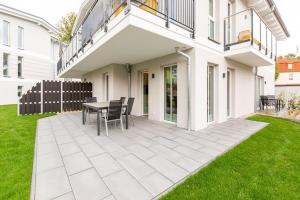 een patio met een tafel en stoelen voor een huis bij Domizil Meerzeit App 6 in Ahlbeck