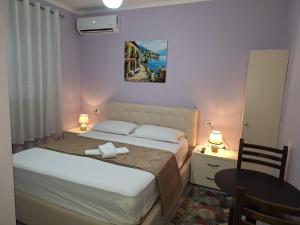 a bedroom with a bed and a table with two lamps at Hotel Sabi in Veminasi +14 photos