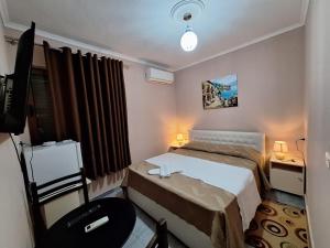 a bedroom with a bed and a desk and a chair at Hotel Sabi in Veminasi