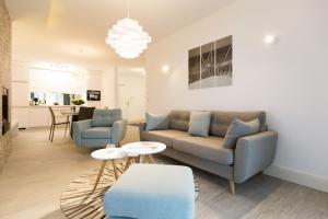 ein Wohnzimmer mit einem Sofa und 2 Stühlen in der Unterkunft Dünenresidenz Heringsdorf, App. 03 in Bansin
