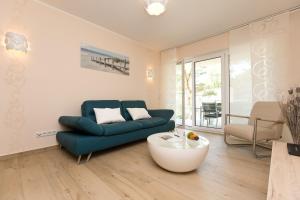uma sala de estar com um sofá azul e uma mesa de centro em Duenenresidenz Heringsdorf App 09 em Bansin