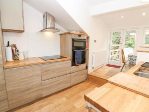 a kitchen with a sink and a stove top oven at Dolphin Cottage in Falmouth