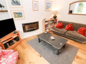 a living room with a couch and a flat screen tv at Dolphin Cottage in Falmouth
