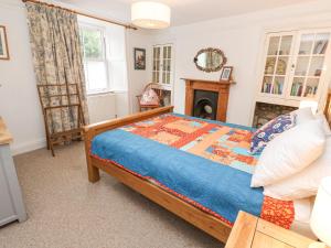 a bedroom with a bed and a fireplace at Dolphin Cottage in Falmouth