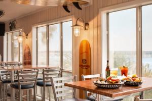 a restaurant with tables and chairs and a surfboard on the wall at Surfside Beach Oceanfront Hotel in Myrtle Beach