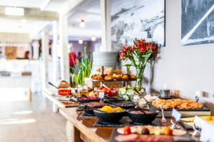 un buffet de comida en una mesa en una tienda en Brygga Restaurant and Rooms, en Å