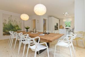 een eetkamer met een houten tafel en witte stoelen bij Ferienhaus Adlerhorst in Bansin