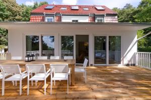 een terras met witte stoelen en een huis bij Ferienhaus Adlerhorst in Bansin