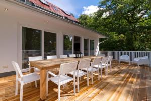 een terras met een houten tafel en witte stoelen bij Ferienhaus Adlerhorst in Bansin +16 foto's