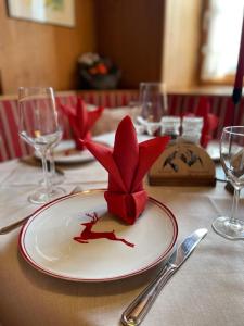 a table with a plate with a red flower on it at Gasthof Herzogstand bei Stefan in Benediktbeuern
