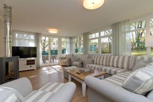 a living room with couches and a flat screen tv at Ferienhaus Amelia Cottage in Neuhof