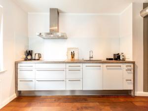 a kitchen with white cabinets and a sink at Ferienhaus Bansin Das Moderne in Bansin