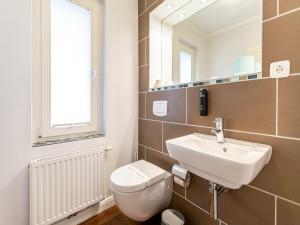 a bathroom with a toilet and a sink and a mirror at Ferienhaus Bansin Das Moderne in Bansin