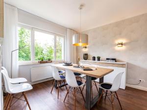 a kitchen with a wooden table and white chairs at Ferienhaus Bansin Das Moderne in Bansin +20 photos