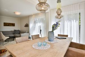Una mesa de comedor con un jarrón de flores encima. en Ferienhaus Hygge Hus, en Sellin 35 fotos más