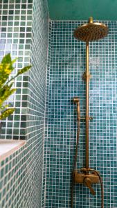 a shower in a bathroom with a blue tiled wall at Casa Canela in Órgiva
