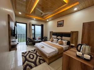 ein Schlafzimmer mit einem großen Bett und einem Balkon in der Unterkunft Hotel Forest View Dalhousie, Banikhet in Dalhousie