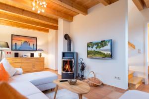 ein Wohnzimmer mit einer weißen Couch und einem Holzofen in der Unterkunft Ferienhaus Silva in Ostseebad Koserow