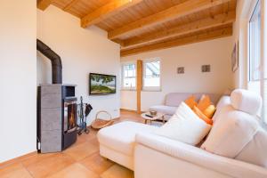 ein Wohnzimmer mit einer weißen Couch und einem Kamin in der Unterkunft Ferienhaus Silva in Ostseebad Koserow