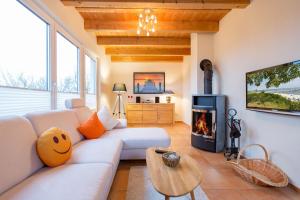 a living room with a white couch and a fireplace at Ferienhaus Silva in Ostseebad Koserow