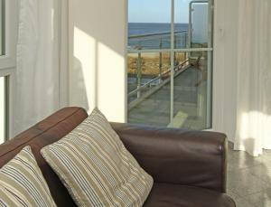 - un canapé brun dans le salon avec vue sur l'océan dans l'établissement Dünenresidenz App B11, à Bansin