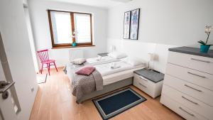 クリニツァ・ズドルイにあるApartamenty Sun & Snow Zielonaのベッドルーム1室(ベッド1台、赤い椅子付)