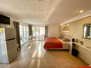 a bedroom with a bed and a refrigerator and a table at Skyline Suite in Playa del Carmen