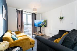 uma sala de estar com 2 sofás e uma televisão de ecrã plano em Morden 2 Bed Apartment - Manchester Old Trafford em Manchester