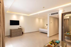 sala de estar con TV y dormitorio en Sunrise Holidays Resort -Adults Only, en Hurghada