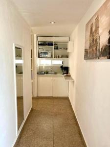 uma cozinha com armários brancos e uma pintura na parede em Skyline Suite em Playa del Carmen
